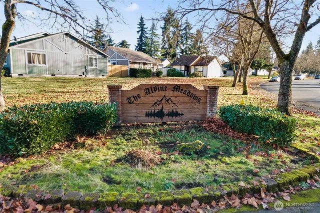 a view of a house with a big yard and large trees