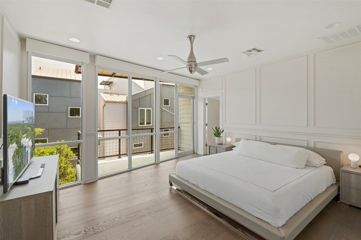 1500 Summit Street, Unit 5 Austin, TX 78741 - Photo 21 of 38 a spacious bedroom with a bed a dresser and a chandelier