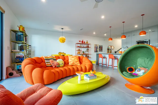 a living room with blue lights with furniture and kitchen view