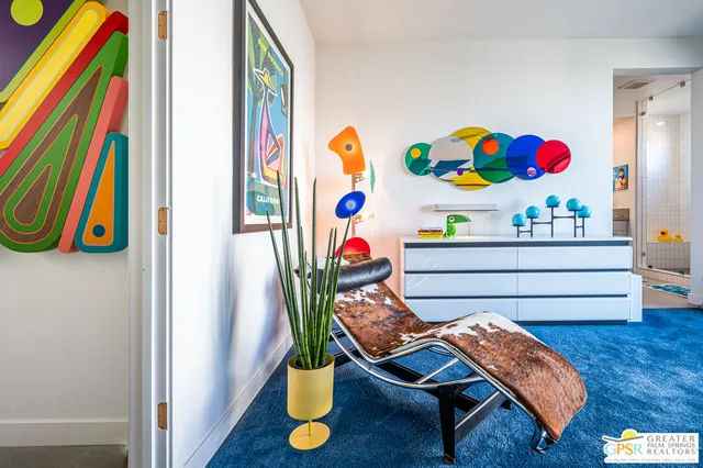 a bedroom with a bed and a lamp on dresser