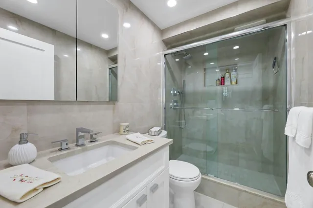 a bathroom with a sink a toilet and shower