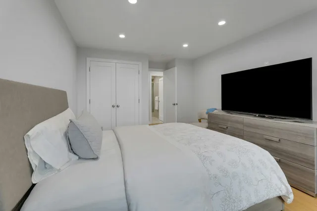a bedroom with a bed and a flat screen tv