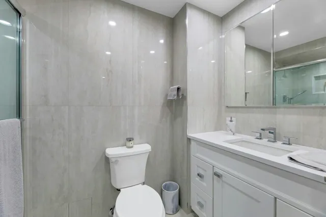 a bathroom with a toilet sink and mirror