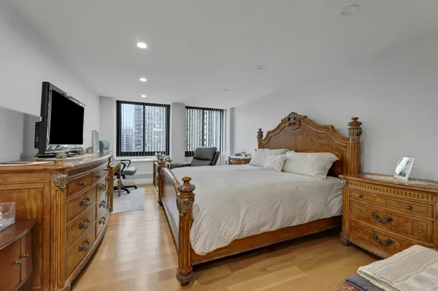 a spacious bedroom with a bed and a flat screen tv