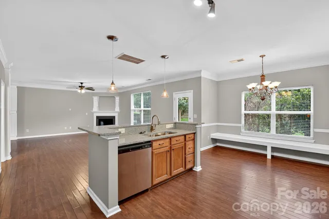a large kitchen with stainless steel appliances granite countertop a sink and wooden floor