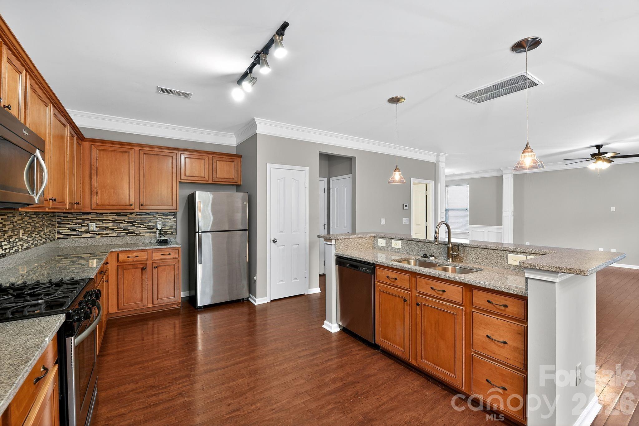 3114 Less Traveled Trail Indian Trail, NC 28079 - Photo 23 of 37 a kitchen with stainless steel appliances granite countertop a sink stove and refrigerator