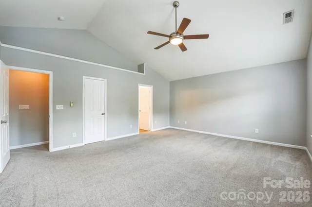 an empty room with a ceiling fan and window