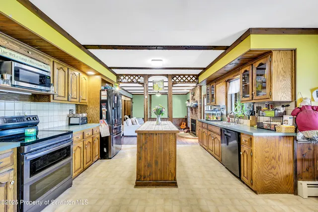 a kitchen with stainless steel appliances kitchen island granite countertop a refrigerator and a stove