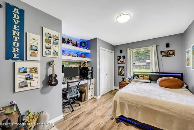 a bedroom with bed and a flat tv screen