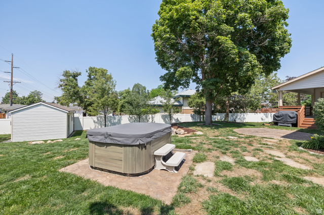 2370 Quail Run Circle East Sandy, UT 84093 - Photo 43 of 54 Backyard featuring a hot tub on a concrete pad, a detached storage shed with vinyl siding, and a wood deck with stairs