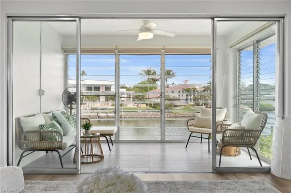 a living room with furniture and floor to ceiling window