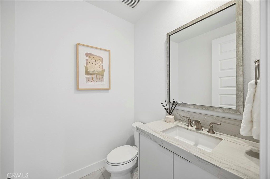 20138 Marlow Lane Porter Ranch, CA 91326 - Photo 14 of 39 a bathroom with a granite countertop toilet a sink and mirror