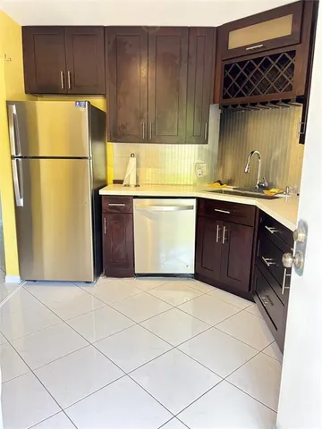 a kitchen with granite countertop a refrigerator a stove a sink and cabinets
