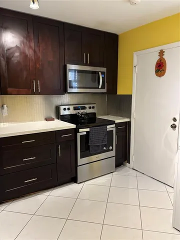 a kitchen with a stove a microwave and wooden cabinets