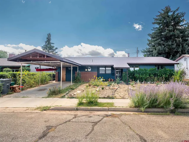 a front view of a house with a yard and potted plants