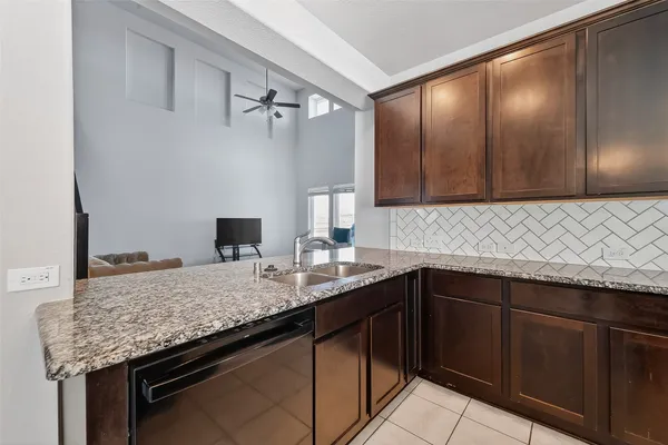a kitchen with a granite countertop sink dishwasher and cabinets