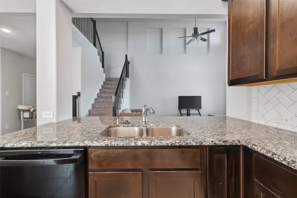 a kitchen with granite countertop a sink and a wooden floor