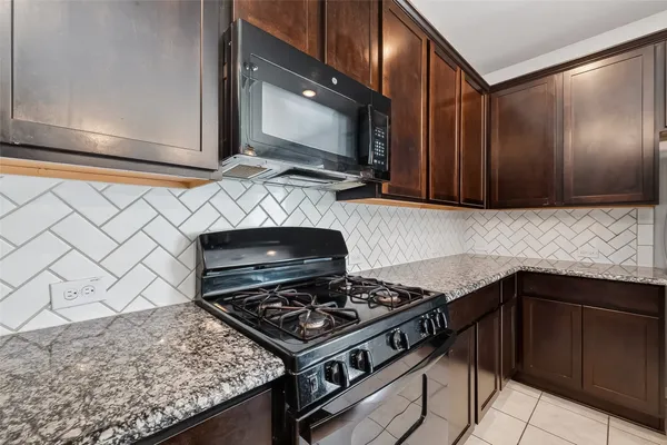 a kitchen with granite countertop a stove and a sink