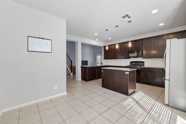 a kitchen with stainless steel appliances granite countertop a refrigerator and a sink