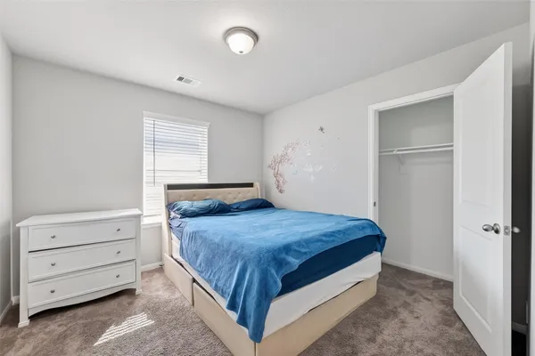 a bedroom with a bed and cabinet