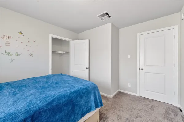 a bedroom with a bed and a painting on the wall