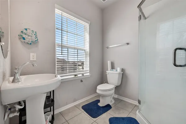 a bathroom with a sink toilet a mirror and a window