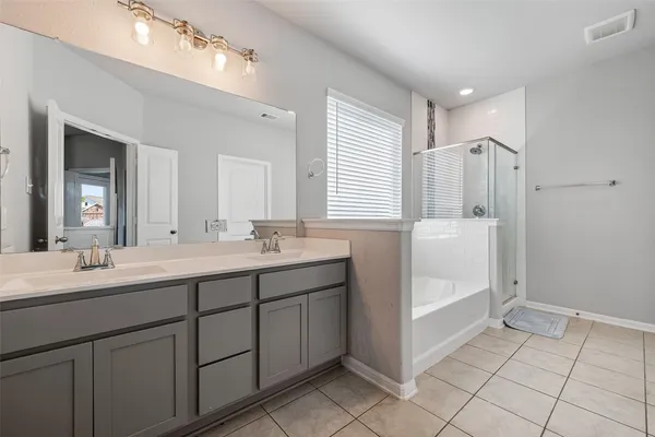 a spacious bathroom with a double vanity sink a mirror and a bathtub