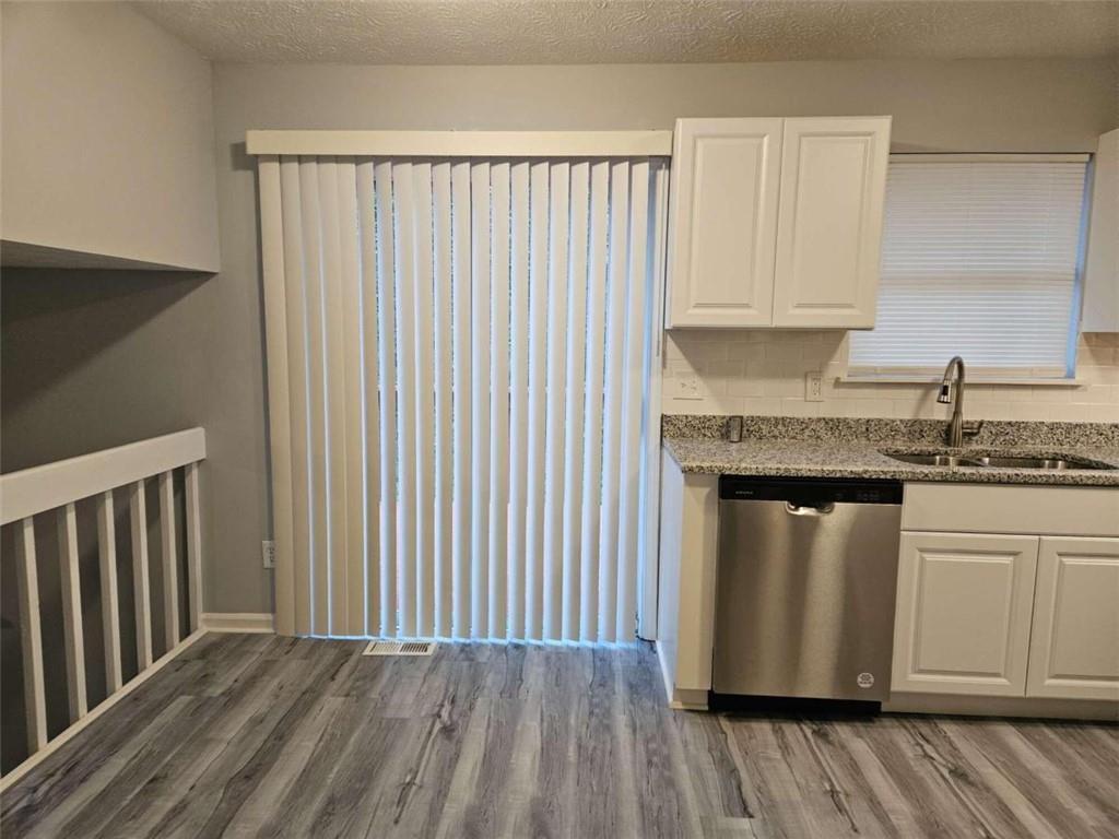 4321 Sebring Walk Decatur, GA 30034 - Photo 5 of 31 a kitchen with granite countertop white cabinets stainless steel appliances and wooden floor