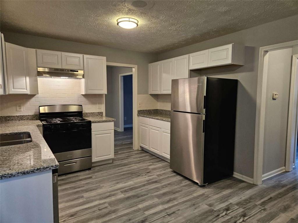 4321 Sebring Walk Decatur, GA 30034 - Photo 7 of 31 a kitchen with a refrigerator stove and wooden cabinets