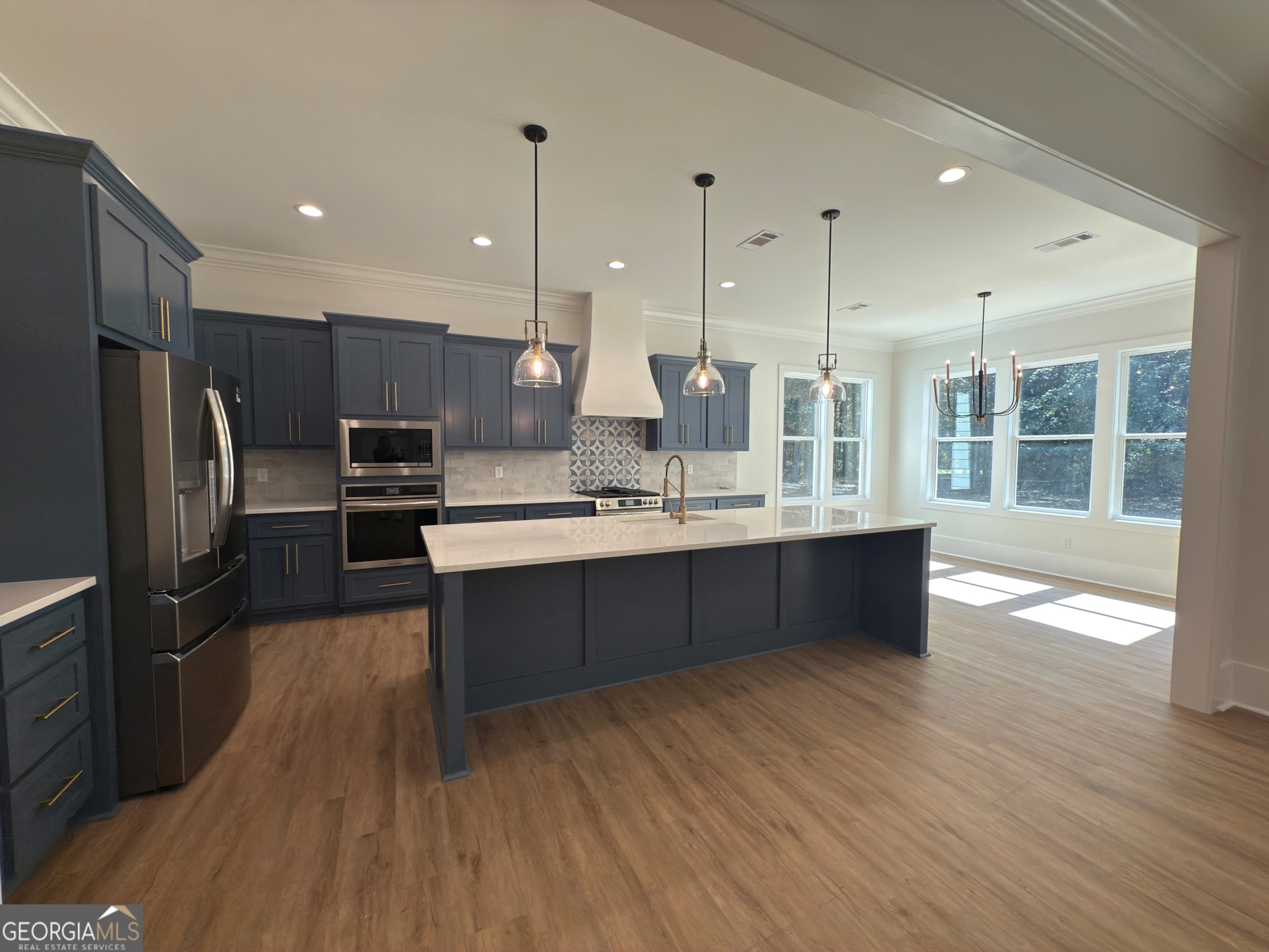 227 Morgan Farm Road Leesburg, GA 31763 - Photo 11 of 33 a large kitchen with stainless steel appliances kitchen island granite countertop a large counter top and wooden floors