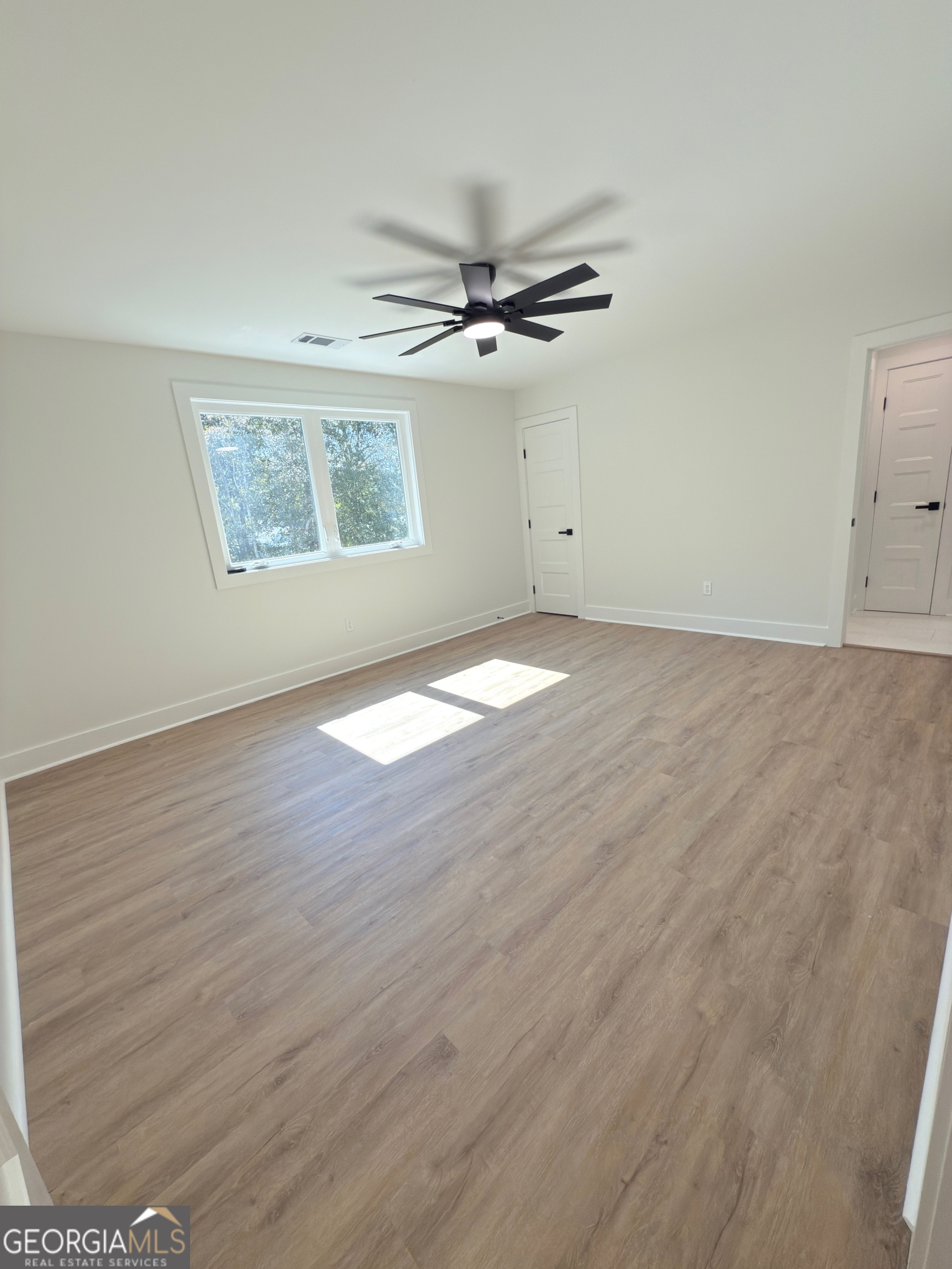 227 Morgan Farm Road Leesburg, GA 31763 - Photo 29 of 33 an empty room with wooden floor ceiling fan and windows