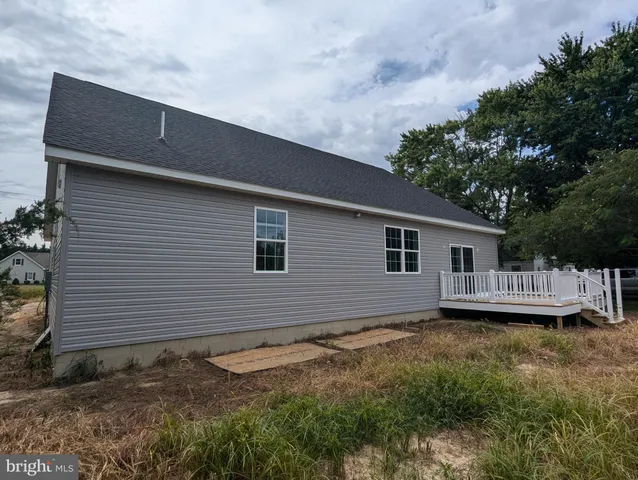 a backyard of a house with wooden deck and barbeque oven