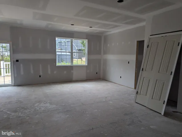 an empty room with windows and closet