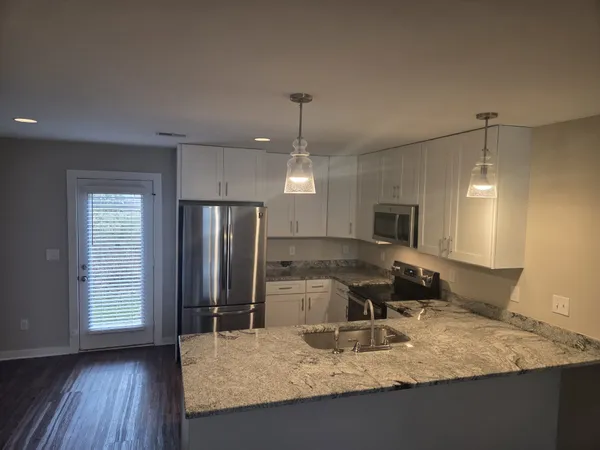 a kitchen with sink refrigerator and microwave