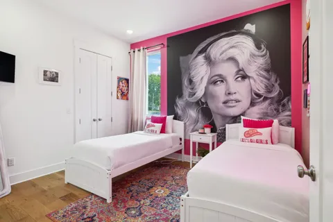 a bedroom with bed and wall painting