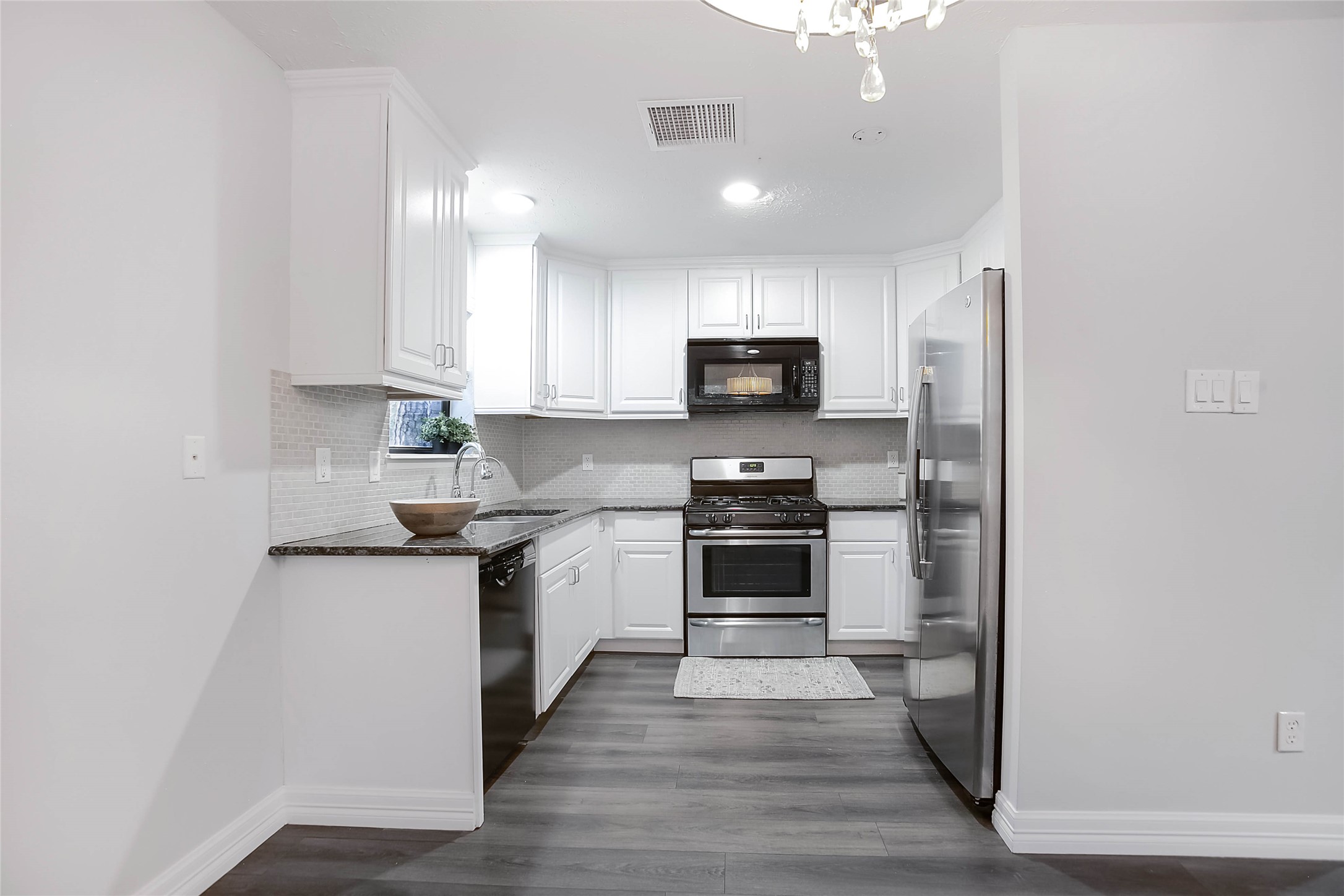 56 East White Willow Circle Spring, TX 77381 - Photo 14 of 45 a kitchen with stainless steel appliances a sink cabinets and wooden floor