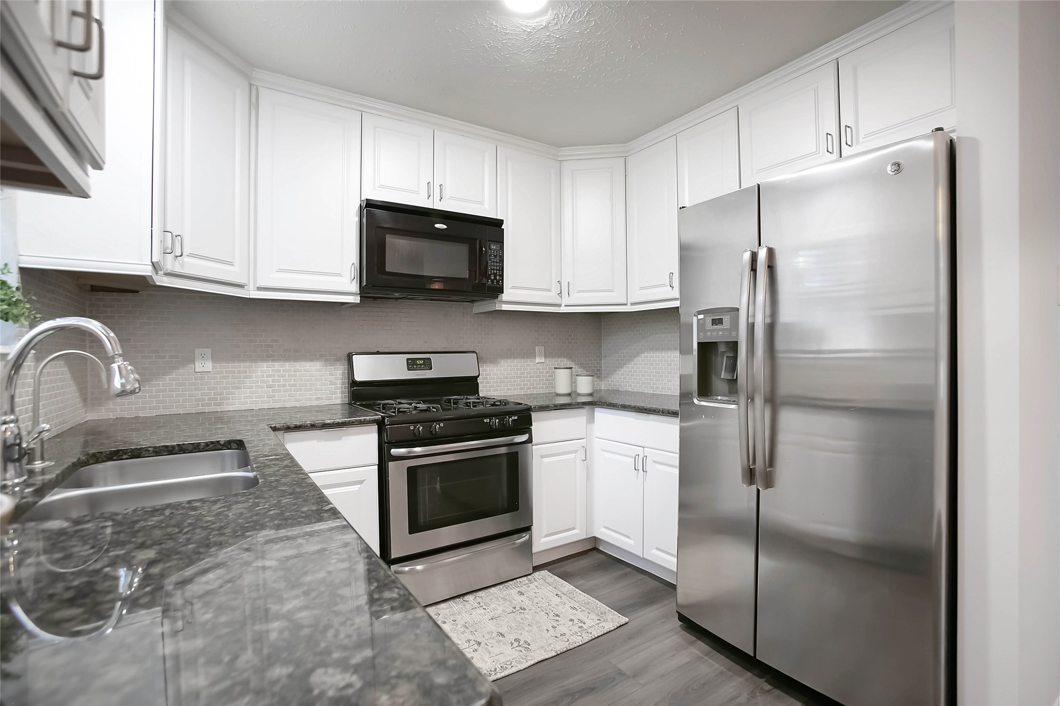 56 East White Willow Circle Spring, TX 77381 - Photo 16 of 45 a kitchen with stainless steel appliances granite countertop a refrigerator sink and stove