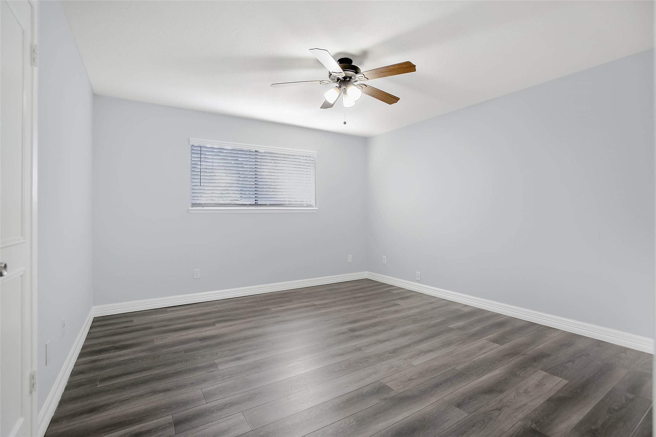 56 East White Willow Circle Spring, TX 77381 - Photo 19 of 45 a view of an empty room with wooden floor and a ceiling fan