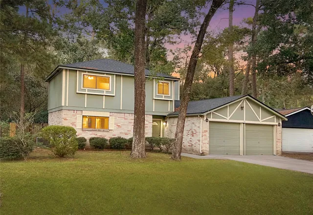 a view of a yard in front of a house with large trees