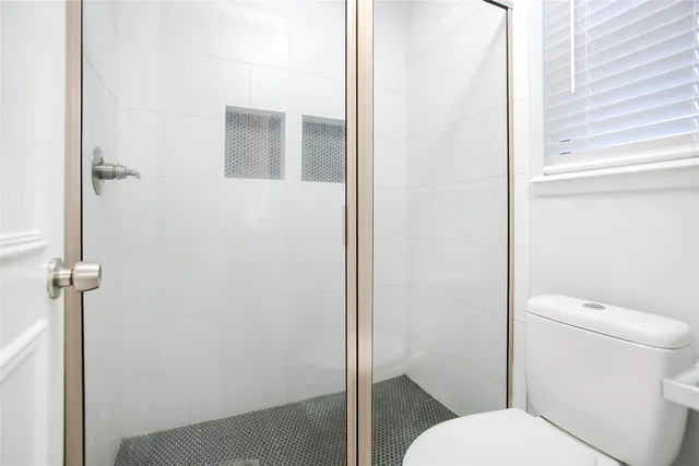 a white toilet sitting next to a bathroom sink