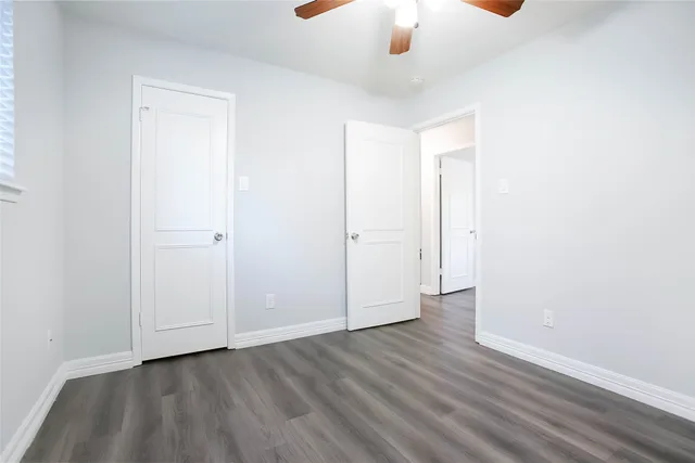 an empty room with wooden floor chandelier fan