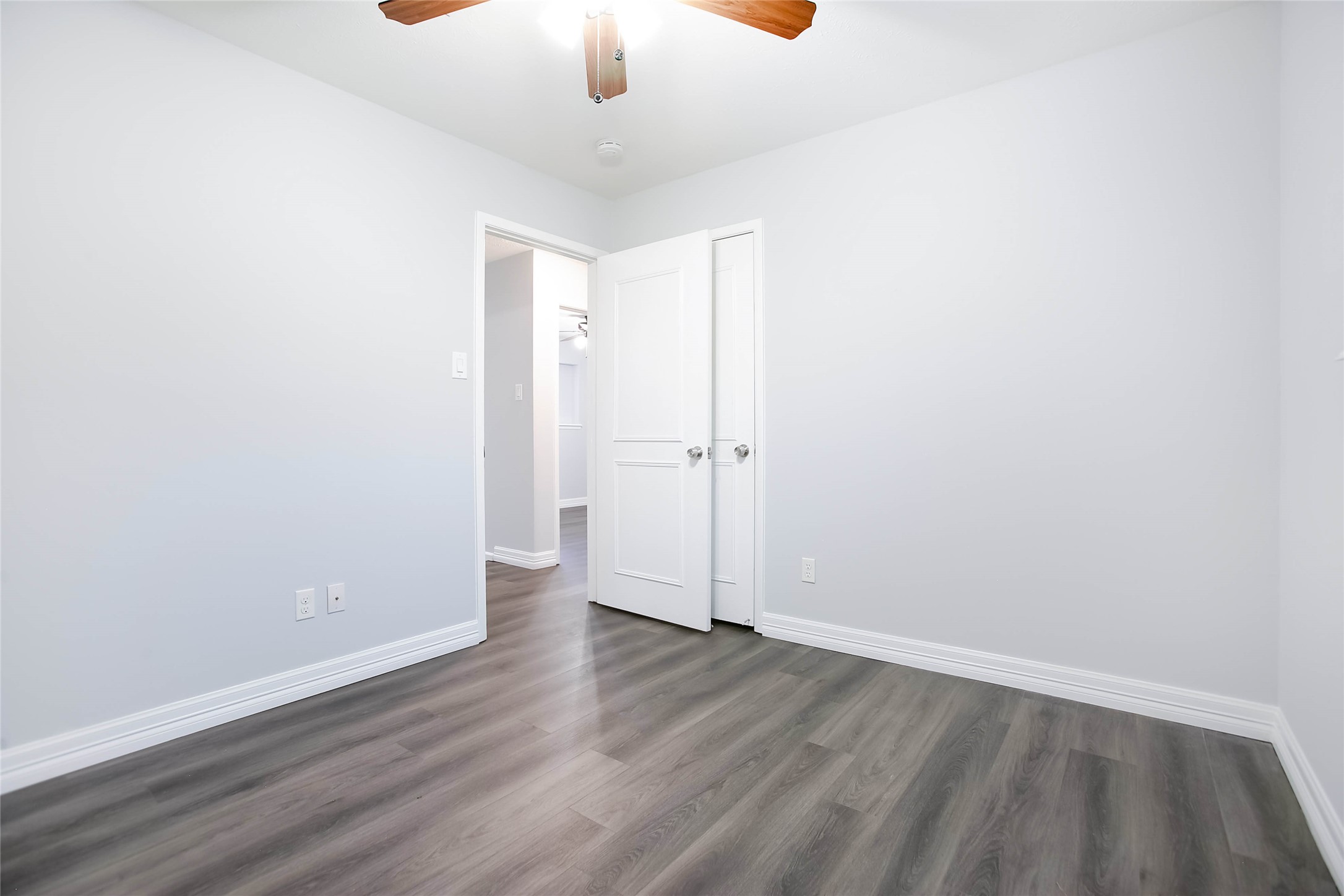 56 East White Willow Circle Spring, TX 77381 - Photo 34 of 45 an empty room with wooden floor and chandelier fan