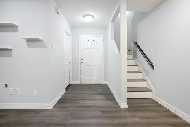 a view of a hallway with wooden floor and entryway