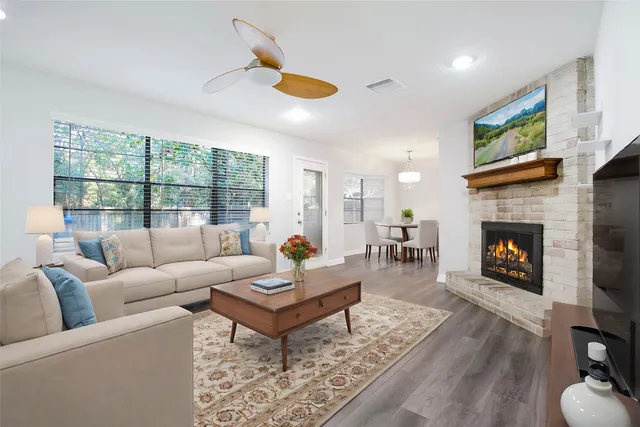 a living room with furniture a fireplace and a flat screen tv