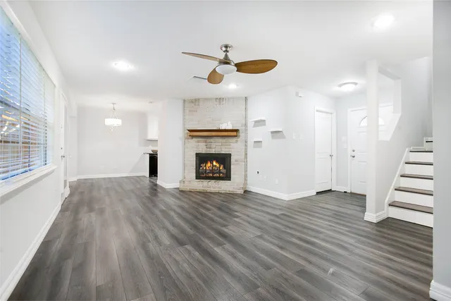 a view of empty room with wooden floor and fireplace