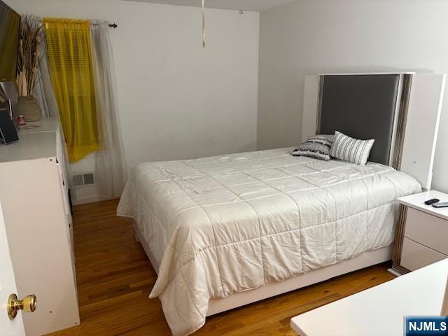 847 Bond Street, Unit 1 Elizabeth, NJ 07201 - Photo 5 of 10 a bedroom with a bed and wooden floor