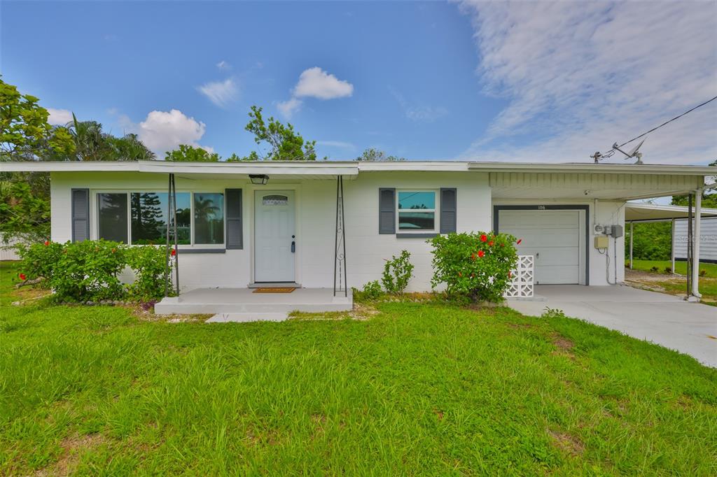 106 West North Branch Road Ruskin, FL 33570 - Photo 3 of 29 a front view of a house with a yard and potted plants