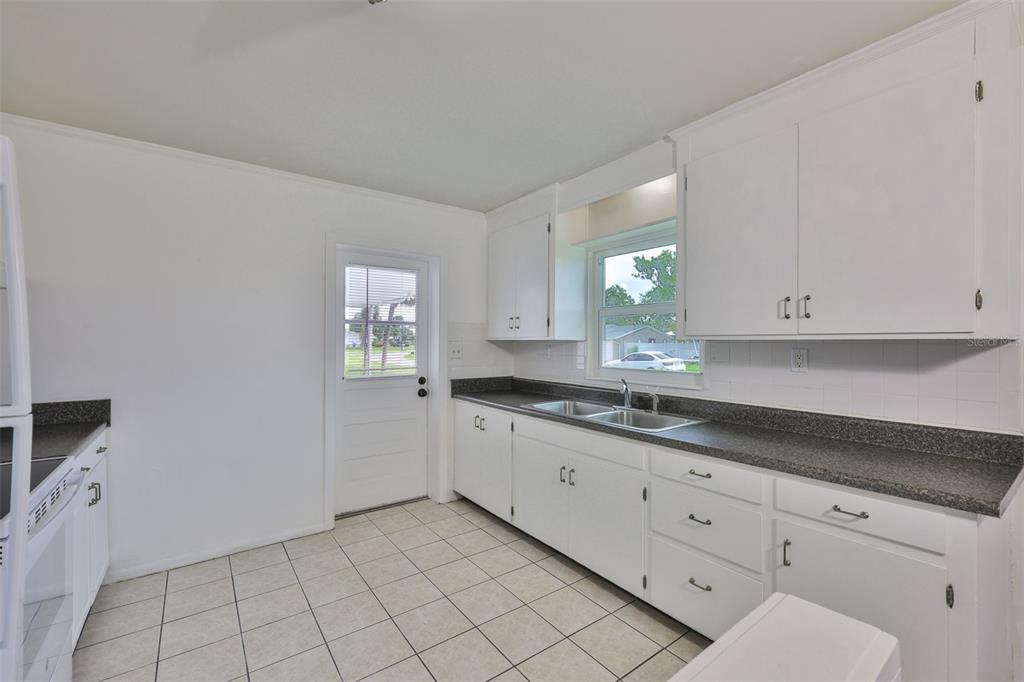 106 West North Branch Road Ruskin, FL 33570 - Photo 8 of 29 a kitchen with granite countertop white cabinets and stainless steel appliances