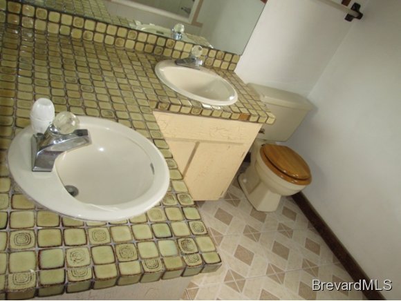 4304 Crooked Mile Road Merritt Island, FL 32952 - Photo 10 of 16 a bathroom with a sink mirror and toilet