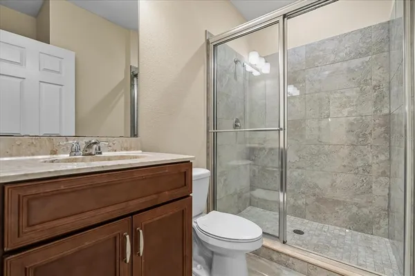 a bathroom with a granite countertop sink toilet and shower